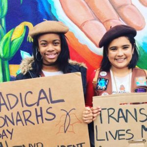 Still shot of two girls holding protest signs from the film We Are the Radical Monarchs