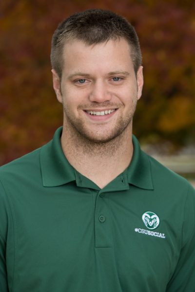 Headshot photo of young man in green CSU polo shirt