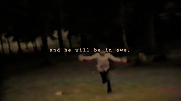 Blurry still image from film "Soon." A child runs with their arms outstretched, with this text superimposed: "and he will be in awe,"
