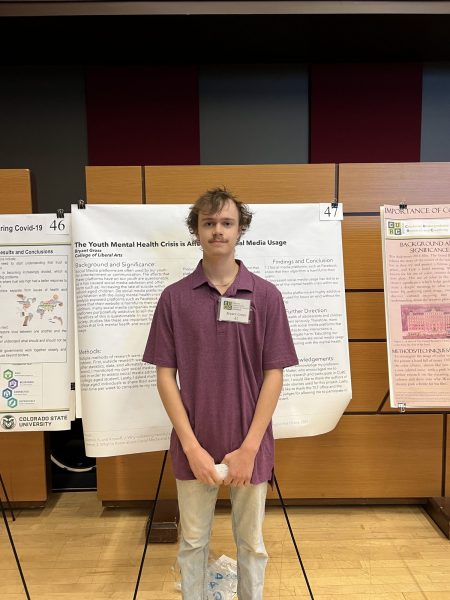Bry Gross poses in front of his research poster at the CURC showcase