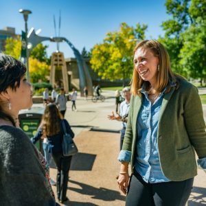 Dr. Elizabeth Williams and a student talking outside the Behavioral Sciences Building