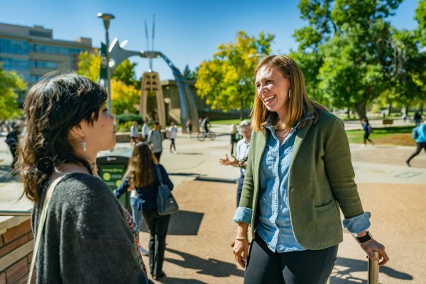 Dr. Elizabeth Williams and a student talking outside the Behavioral Sciences Building