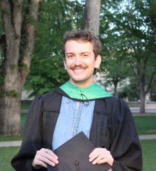 Headshot of Andrew Dewey graduating from Colorado State University outside with trees and grass behind him. 